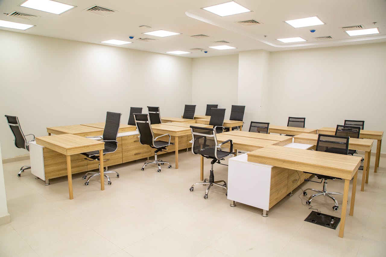Spacious modern office with wooden desks and ergonomic chairs, ideal for team workspace.